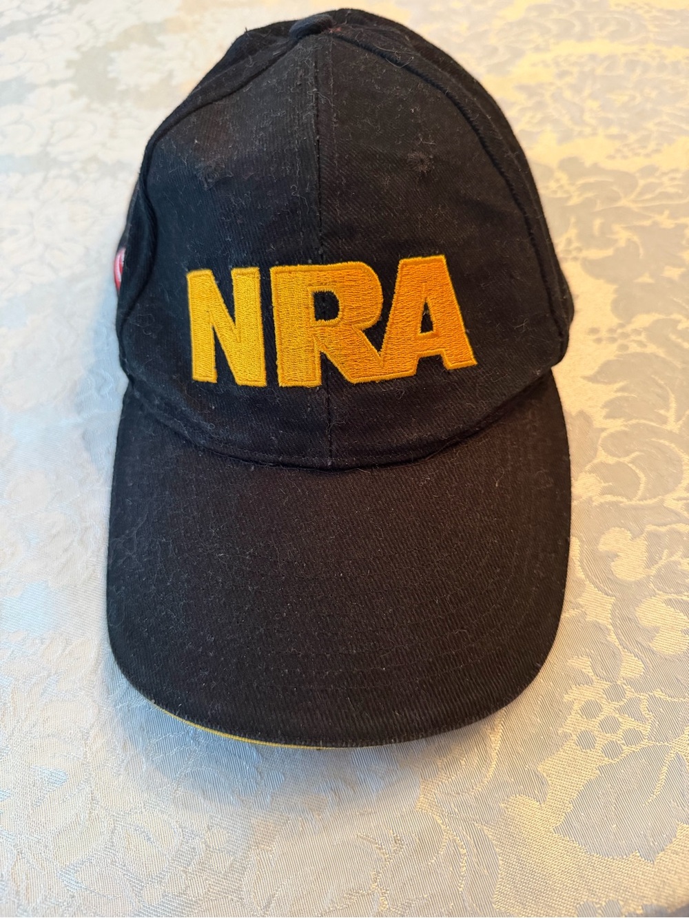 NRA Embroidered Black Cap with Gold Lettering
